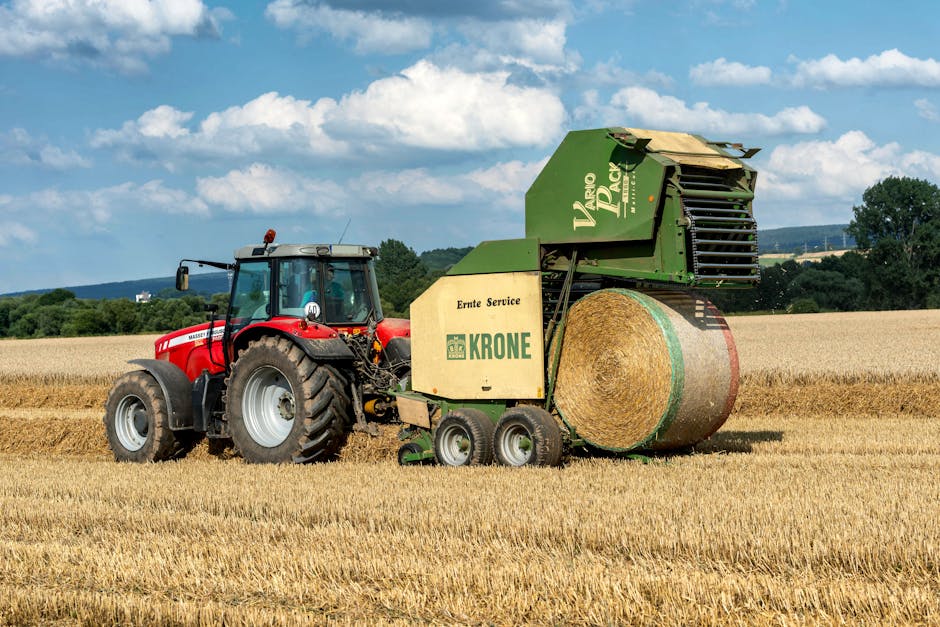 A tractor and baler working in a wheat field during summer in Höxter, Germany.